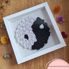 ¿Buscas una forma de decorar tu hogar con estilo y equilibrio? Entonces este impresionante Bloom Box de Yin Yang es la pieza perfecta para ti. Se trata de un cuadro artesanal hecho con flores de papel blancas y negras, que forman el símbolo de la dualidad y la armonía. El marco blanco le da un toque de elegancia y contraste, mientras que las flores de papel de colores que lo rodean le aportan un poco de alegría y diversión.