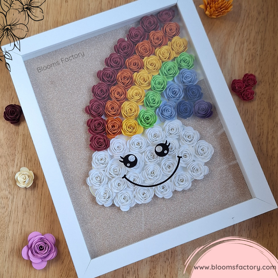 Decora tu hogar con este hermoso cuadro decorative hecho a mano, que muestra un arco iris y una nube de flores de papel enrolladas en colores vivos. Un regalo original y creativo para cualquier ocasión.