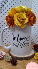 Taza decorativa coronada con flores de papel hechas a mano y en el base tiene escrito "Mom 24/7/365"